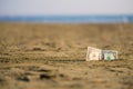 Banknote of value of one dollar in the the sand on the beach. Concept of cheap travel and vacation. Royalty Free Stock Photo