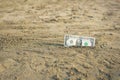 Banknote of value of one dollar in the the sand on the beach. Concept of cheap travel and vacation. Royalty Free Stock Photo