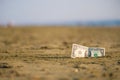 Banknote of value of one dollar in the the sand on the beach. Concept of cheap travel and vacation. Royalty Free Stock Photo