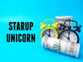 Banknotes and clock with text STARUP UNICORN