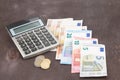 Calculator amd Euro banknotes on wooden background. Photo for tax, profit and costing. Royalty Free Stock Photo