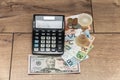 Banknotes and coins of the Republic of Belarus, fifty US dollars, an hourglass and a calculator on a wooden background. Royalty Free Stock Photo