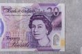 Banknotes with denomination and 20 images of Queen Elizabeth portrait on a gray background