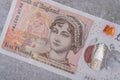 Banknotes in denominations of 10 with the image of a portrait of Jane Austen on a gray background