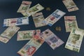 Banknotes of different denominations of Mexican currency, scattered on a blue superfice