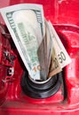 Banknotes, dollars in the fuel filler of a red car Royalty Free Stock Photo