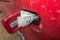 Banknotes, dollars in the fuel filler of a red car Royalty Free Stock Photo