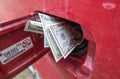 Banknotes, dollars in the fuel filler of a red car Royalty Free Stock Photo
