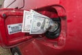 Banknotes, dollars in the fuel filler of a red car Royalty Free Stock Photo