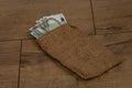 Banknotes of 100 euros in a bag on a wooden background. Royalty Free Stock Photo