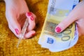 Banknotes in euros for the treatment of coronavirus in female hands. Woman holds thermometer and money, close up