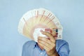 5000 banknotes folded fan cover the face of the businessman. Russian banknotes rubles in hand