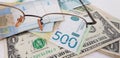 Banknotes of hryvnia dynars and dollars seen through eyeglasses Royalty Free Stock Photo