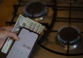 The banknotes lie next to a burning gas burner. The concept is to increase the cost of supply , payment for natural gas