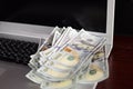 Banknotes over laptop keyboard dollars money Royalty Free Stock Photo