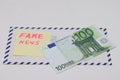 Banknotes on a postal envelope on a light background. Fake news sticker on the envelope. Corrupt journalism. Fake news.