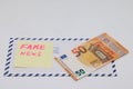 Banknotes on a postal envelope on a light background. Fake news sticker on the envelope. Corrupt journalism. Fake news.