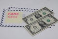 Banknotes on a postal envelope on a light background. Fake news sticker on the envelope. Corrupt journalism. Fake news