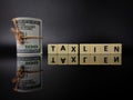 Banknotes with word TAX LIEN on black background with reflection Royalty Free Stock Photo