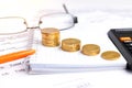 Bankruptcy concept. Close-up coins, pen, calculator and glasses at financial report Royalty Free Stock Photo