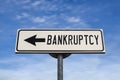Bankruptcy white road sign with arrow, arrow on blue sky background Royalty Free Stock Photo