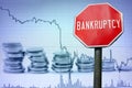 Bankruptcy sign on economy background - graph and coins Royalty Free Stock Photo