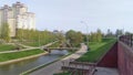 On the banks of the city canal there are grassy lawns and growing trees. There are paved walkways along the canal. The bridge is m Royalty Free Stock Photo