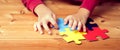 Banner, An autistic child`s hands play colorful jigsaw puzzle symbol of public awareness for autism spectrum disorder. World
