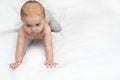 Banner background with copy space. Baby boy nine months crawling at home on a white blanket. He leans well on his hands holds his