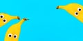 Banner with banana fruits with funny googly eyes on bright blue background