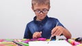 Banner boy in a blue shirt and glasses sits at a table on a white background Creative activities hobby drawing