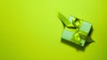 Banner of brown paper gift box with a yellow ribbon bow on bright green background on the right with copy space. Flat lay Saint Royalty Free Stock Photo