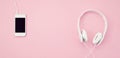 Banner with the cell phone and headphones over the pink background. Music, entertainement, online playlists Royalty Free Stock Photo