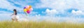 Banner Cheerful cute girl holding balloons running green meadow white cloud and blue sky with happiness. Panorama Hands holding