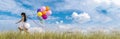 Banner Cheerful cute girl holding balloons running green meadow white cloud and blue sky with happiness. Panorama Hands holding