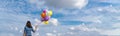 Banner Cheerful cute girl holding balloons running green meadow white cloud and blue sky with happiness. Panorama Hands holding