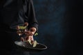 Banner, Chef fries an octopus close-up, in a frying pan with limes, freezing in motion on a dark blue background, seafood and Royalty Free Stock Photo