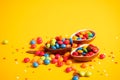 Banner. Chocolate Easter eggs with colored candies on a yellow background