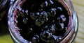 Banner of chokeberry jam in a glass jar. Sweet from aronia