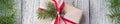 Banner of Christmas background with gift and fir tree on white wooden table. Top view with copy space. Royalty Free Stock Photo