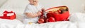 Banner Close-up Christmas Baby in Santa Hat, Child holding christmas bauble near Present Gift Box over Holiday Lights Royalty Free Stock Photo