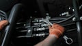 Banner with close up view of hydraulic pipes of heavy industry machine and hands of mechanic. Low key