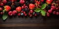 A banner with colorful fresh berries and green leaves on dark wooden background. Advertisement for market, farmer or vegan concept