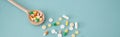 Banner colorful pills and capsules on wooden spoon Royalty Free Stock Photo