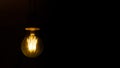 Banner copy space. Dim light bulb on a black background. Gloomy black background. Old dirty lamp Royalty Free Stock Photo