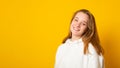 Banner copy space. Portrait of a beautiful teenage girl in a white hoodie cute smiling on yellow background Royalty Free Stock Photo