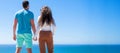 Banner of couple in love embracing on sea beach, young man and woman holding hands looking at sea from top, back view Royalty Free Stock Photo