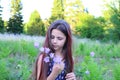 Banner with a cute girl in a blue romper looking at beautiful purple field bells in her hand. Royalty Free Stock Photo