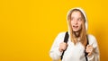 Banner. Cute adorable girl dressed white hoodie on yellow background with backpack. Portrait of cool schoolgirl with backpack