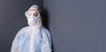 Banner. A doctor in protective overalls, goggles in a gray wall with side space. The concept of combating coronavirus Royalty Free Stock Photo